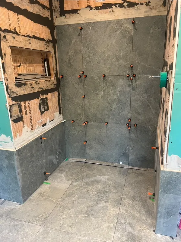Grey tiles going up with levelling clips