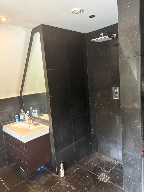 The old black-tiled shower